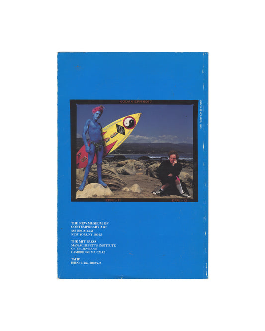 Exhibition catalogue back cover, Impresario: Malcolm McLaren & The British New Wave, New Museum of Contemporary Art / The MIT Press, New York / Cambridge MA, 1988. Bright blue ground. Centre: inset colour photograph within black film-strip border — blue-painted male figure holding yellow surfboard with yin-yang motif; seated male figure in black clothing on rocks; coastal landscape behind; 'KODAK EPR 6017' printed to film strip upper edge; 'EPR 11' and 'EPR 12' lower. Lower left: black sans-serif — 'THE NEW