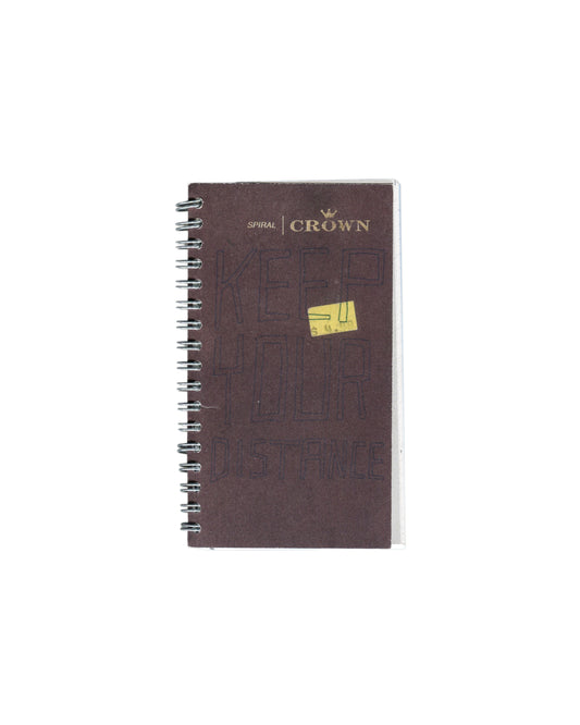 Facsimile artist sketchbook, Rafael Melendez, Keep Your Distance: A 2006 Facsimile Sketchbook, The Academy of Realness, 2021. Edition of 2. 8 × 15.5 cm, 102 pages, spiral-bound. Dark brown Crown Spiral notebook cover; 'SPIRAL | CROWN' logo with crown motif upper centre in gold. Yellow N.Y. Central price sticker centre. Silver spiral binding left edge. Scuffs and handling marks visible as reproduced from source notebook.