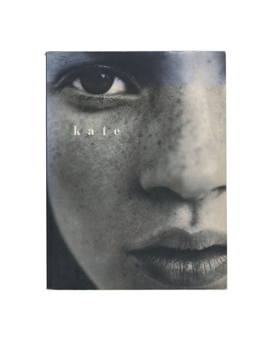 Kate Moss, Kate, Pavilion Books Ltd, London, 1997. Softcover, 15.5 × 21 cm. Extreme close-up monochrome photograph — Kate Moss's face cropped to eye, nose and lips; freckled skin; small white serif title 'k a t e' centred. Light cover wear, good vintage condition.

