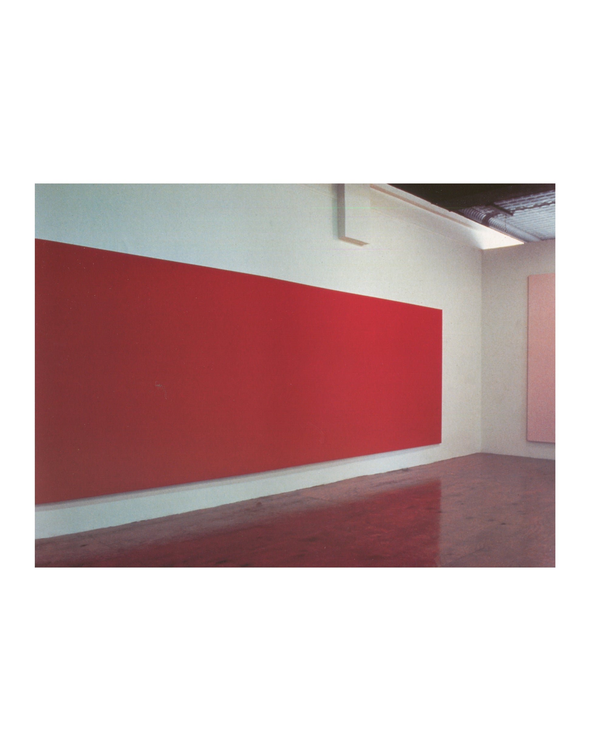 Interior page, Olivier Mosset, Verlag Lars Müller, Baden, 1990. Colour installation photograph — large horizontal hot pink monochrome canvas spanning the full gallery wall; dark wood floor; smaller pale pink canvas at right edge. Very good condition.

