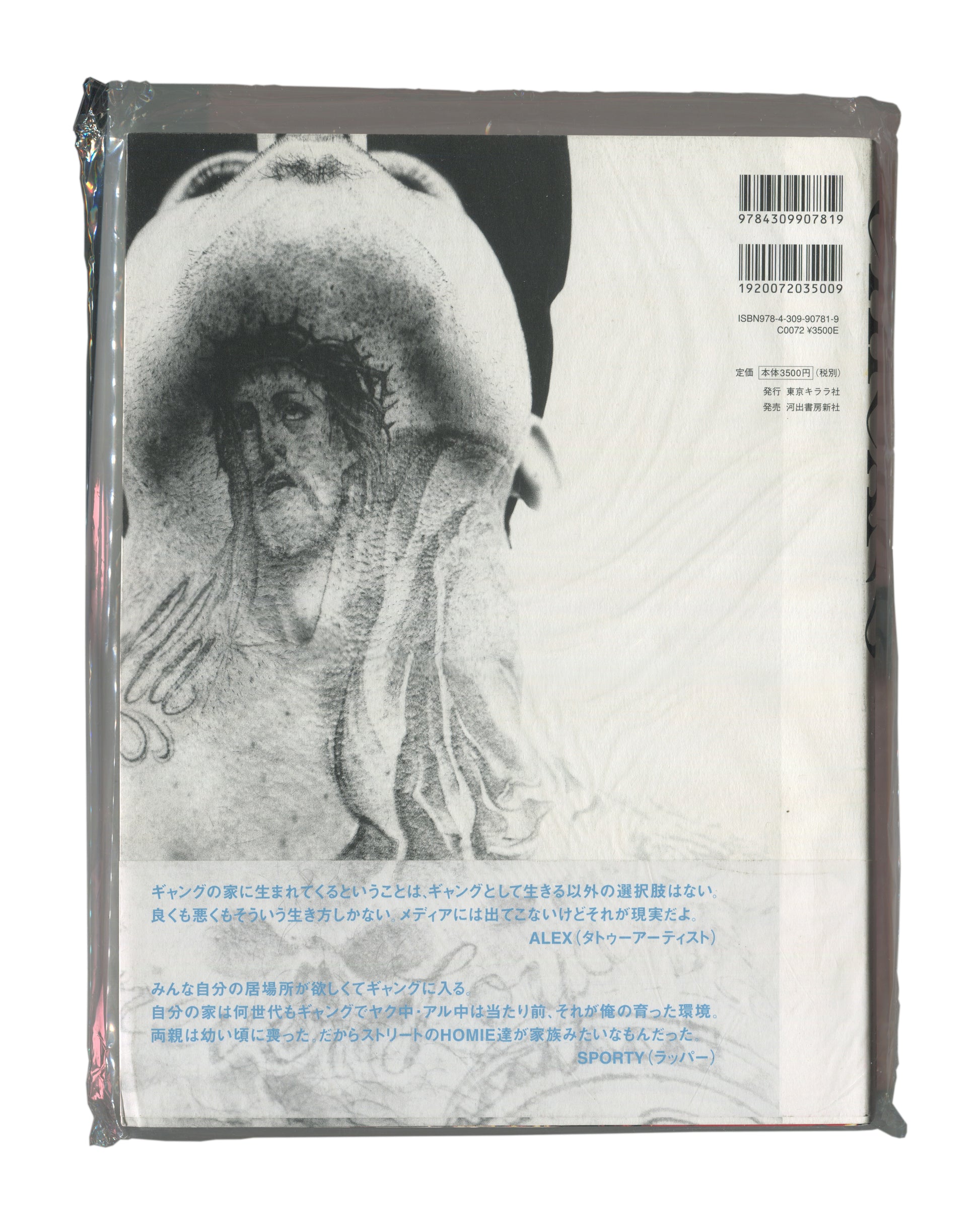 Photobook back cover with obi, Keisuke Nagoshi, CHICANO, Tokyo Kirara-sha / Kawade Shobo Shinsha, Japan, 2008. Sealed in original distributor shrinkwrap. Full-bleed black-and-white photograph — continuation of tattooed torso image from front cover. Upper right: two barcodes and publisher details — 'ISBN978-4-309-90781-9 / C0072 ¥3500E / 発行 東京キララ社 / 発売 河出書房新社'. Lower third: obi with two Japanese text quotations attributed to ALEX (tattoo artist) and SPORTY (rapper). Shrinkwrap shows light surface rubbing 