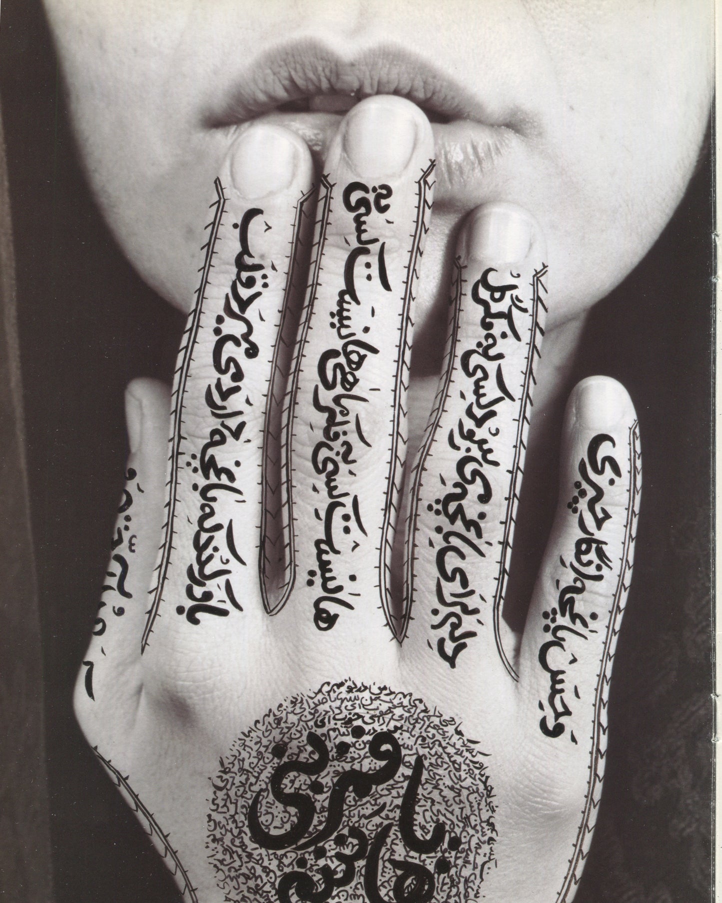 Shirin Neshat, Women of Allah series, hand raised to lips, Persian calligraphy covering fingers and palm 