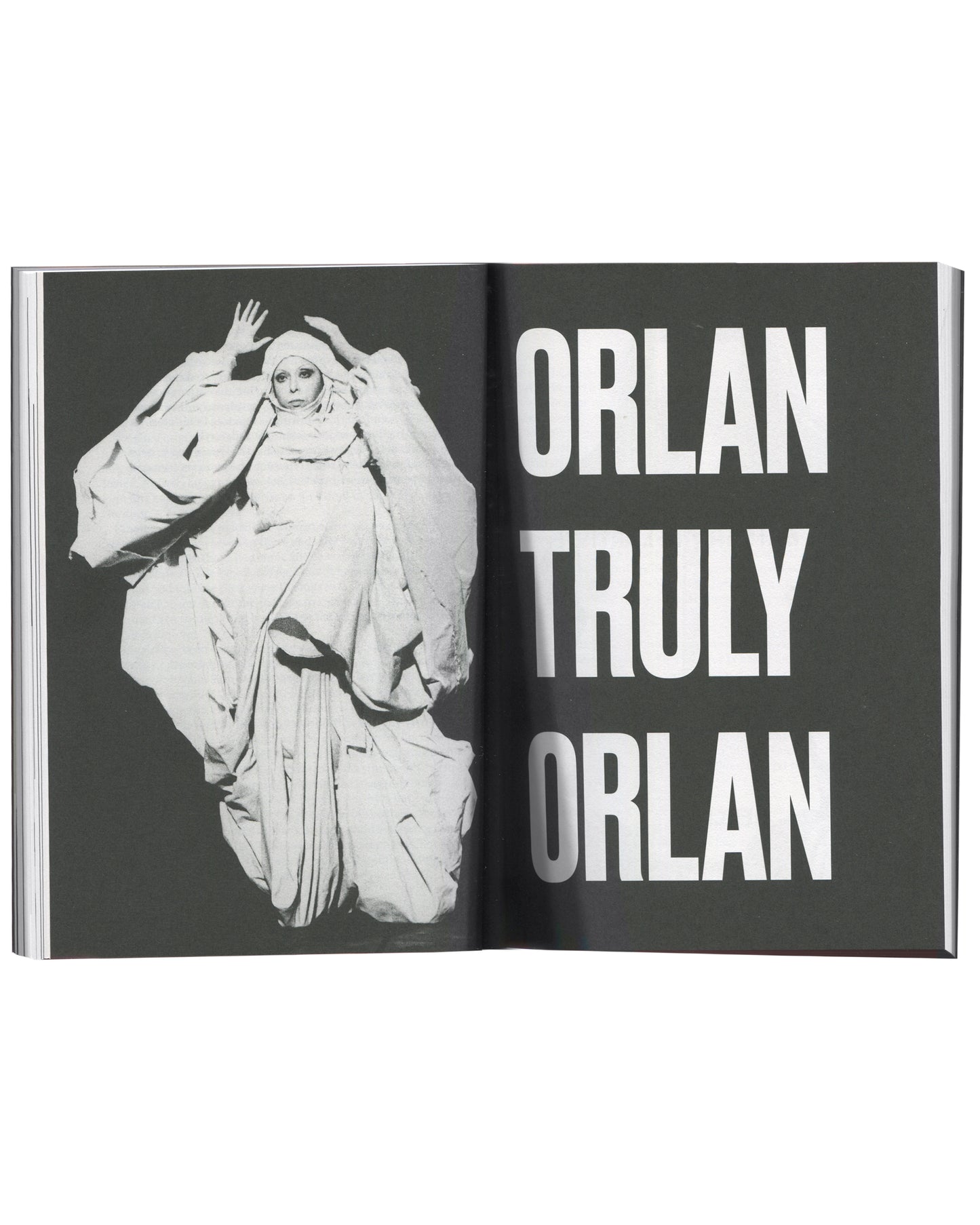 ORLAN, Strip-Tease, 2024, interior spread, ORLAN in white draped costume, chapter title "ORLAN TRULY ORLAN" in white on dark ground