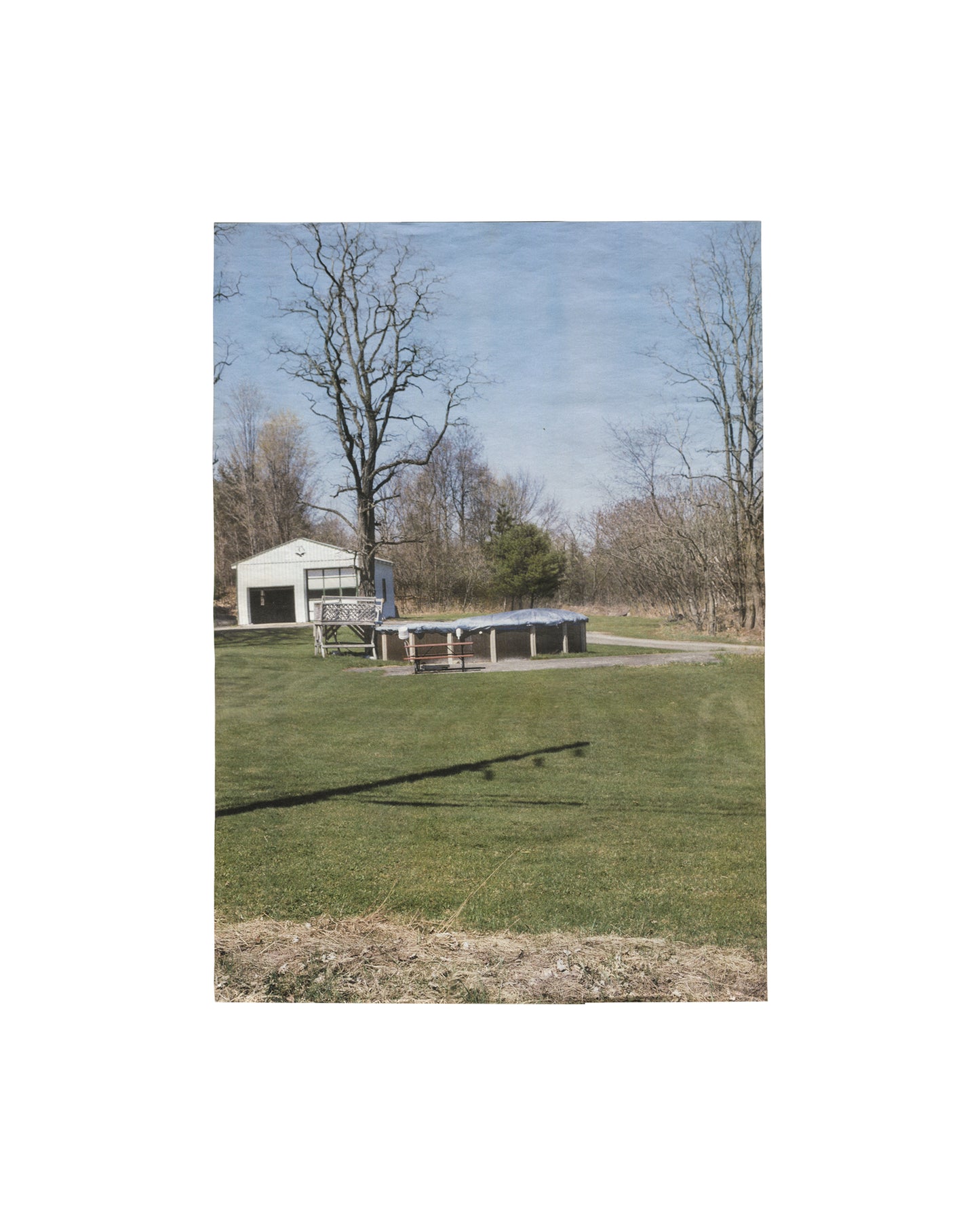 Folded artist publication/poster, Richard Prince, 3rd Place, Point d'Ironie no. 39, Agnès b. / Point d'Ironie, Paris, April 2006. Ed. Hans Ulrich Obrist. Offset on lightweight paper. Front face: colour photograph — rural American landscape, open green lawn, white garage structure, bare trees, blue sky; diagonal shadow across grass foreground. Light handling and original fold lines, good vintage condition.

