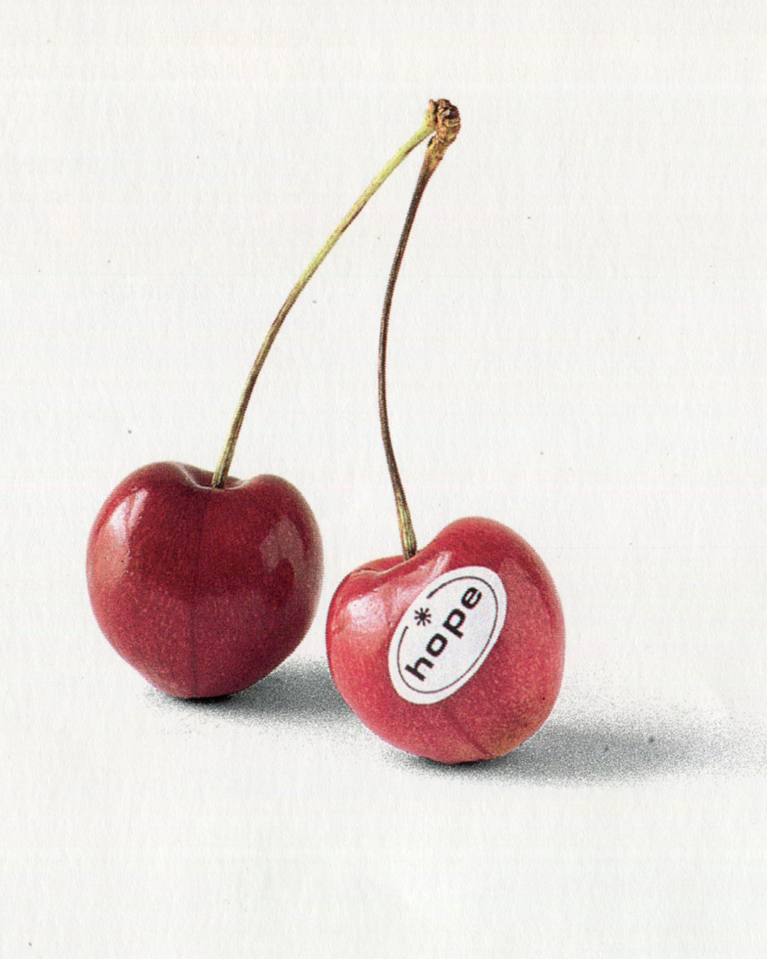 Two cherries, one with a hope sticker, full-page photograph, frieze Issue 1