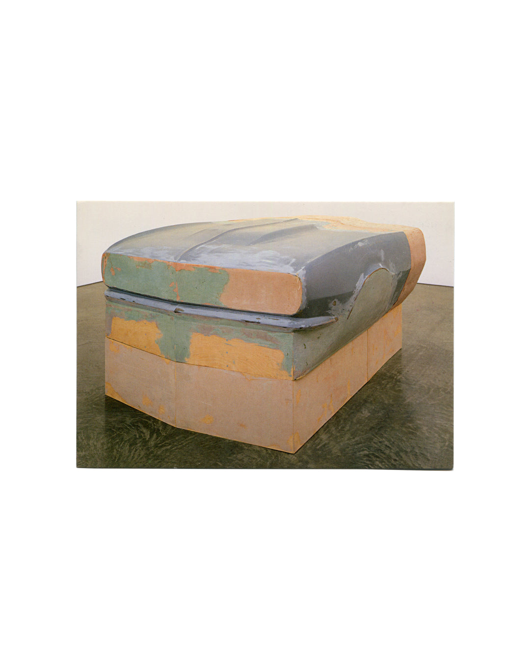 Postcard recto, Richard Prince, Spiritual America / Continuation, Solomon R. Guggenheim Museum, New York, 2007. Offset colour reproduction. Three-quarter view of sculpture — large low-profile form resembling a car hood or bonnet; fiberglass, polyester resin, acrylic and wood; surface painted in mottled grey-blue and ochre/terracotta tones with visible brushwork; resting on a plain rectangular plinth of similar patchy colouring; dark reflective gallery floor, white wall behind. Light handling wear, very good