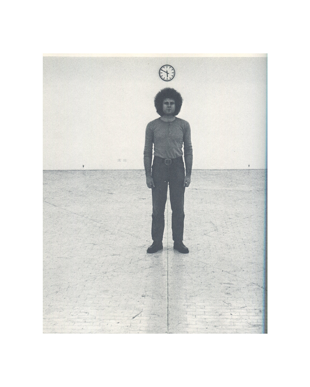 Klaus Rinke, Zeit Raum Körper Handlungen, 1972, interior, b&w photograph, figure standing in empty room, clock mounted on wall above 