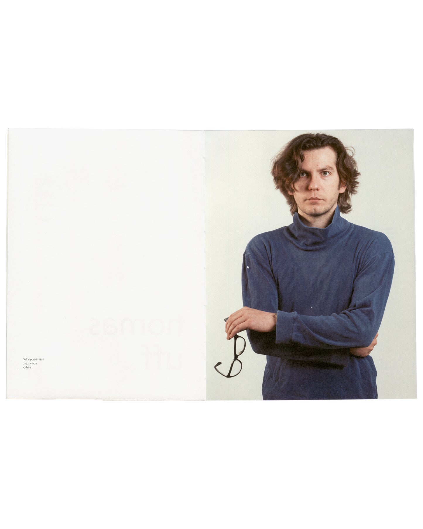 Thomas Ruff, Portraits, large-format portrait of young man in blue turtleneck holding glasses, interior spread