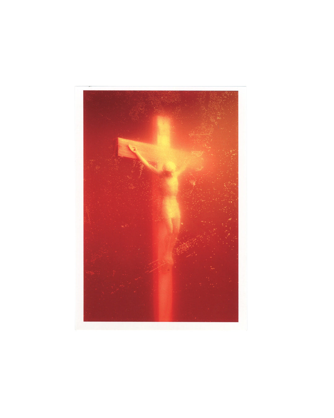 Official Andres Serrano exhibition postcard reproducing *Piss Christ (Immersions)* (1987), showing a glowing crucifix suspended within an amber-red field of light.