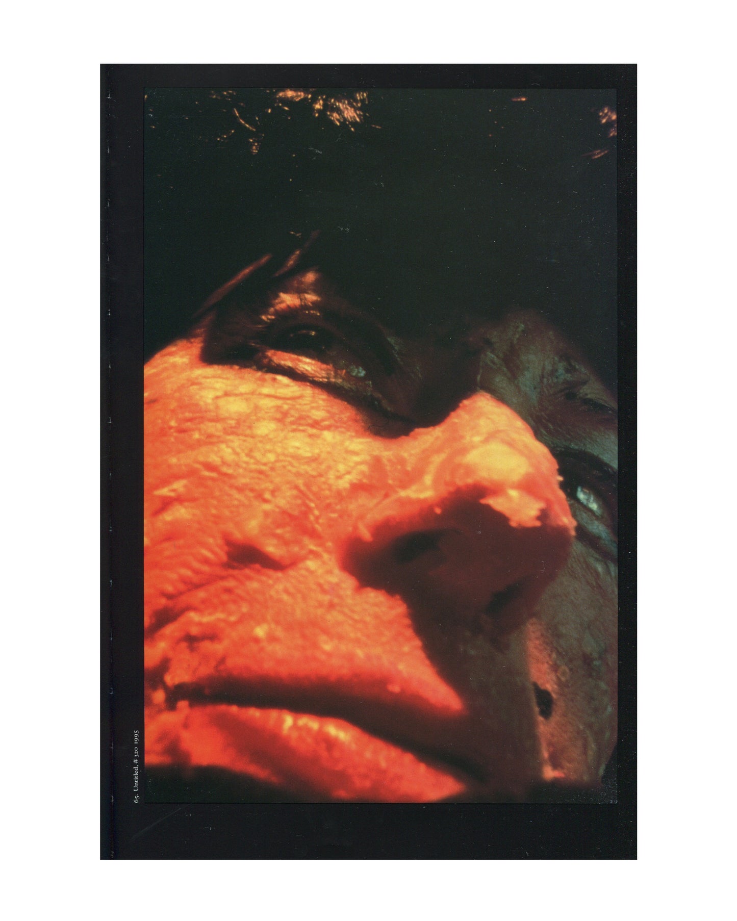 Cindy Sherman, 1997 catalogue, interior: colour Untitled #150, 1985 — extreme close-up of orange prosthetic face, distorted nose and lips, dark ground
