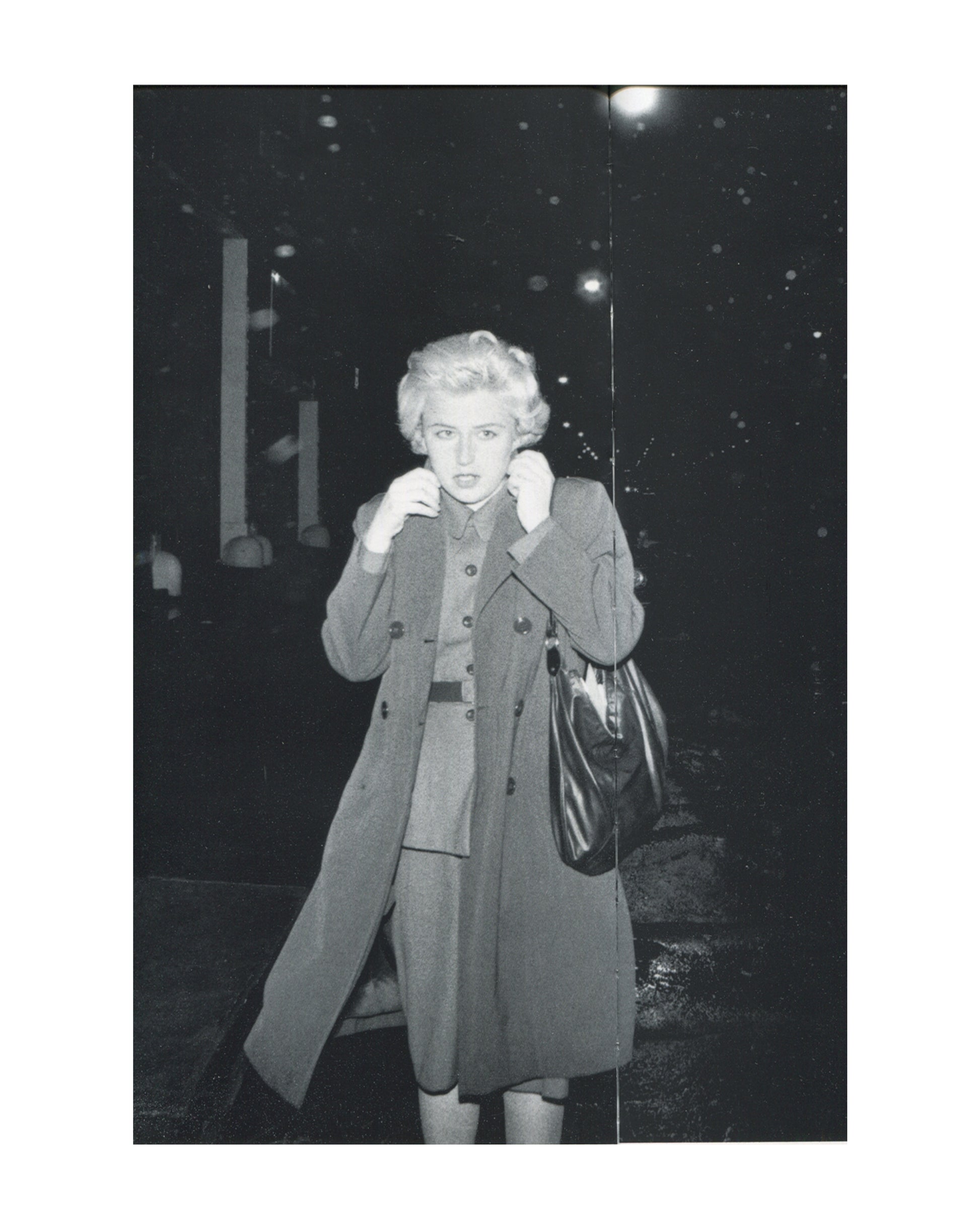 Cindy Sherman, Untitled #54, 1980, b&w Film Still — blonde Sherman in double-breasted coat, clutching collar, handbag, caught outside at night, street lights behind