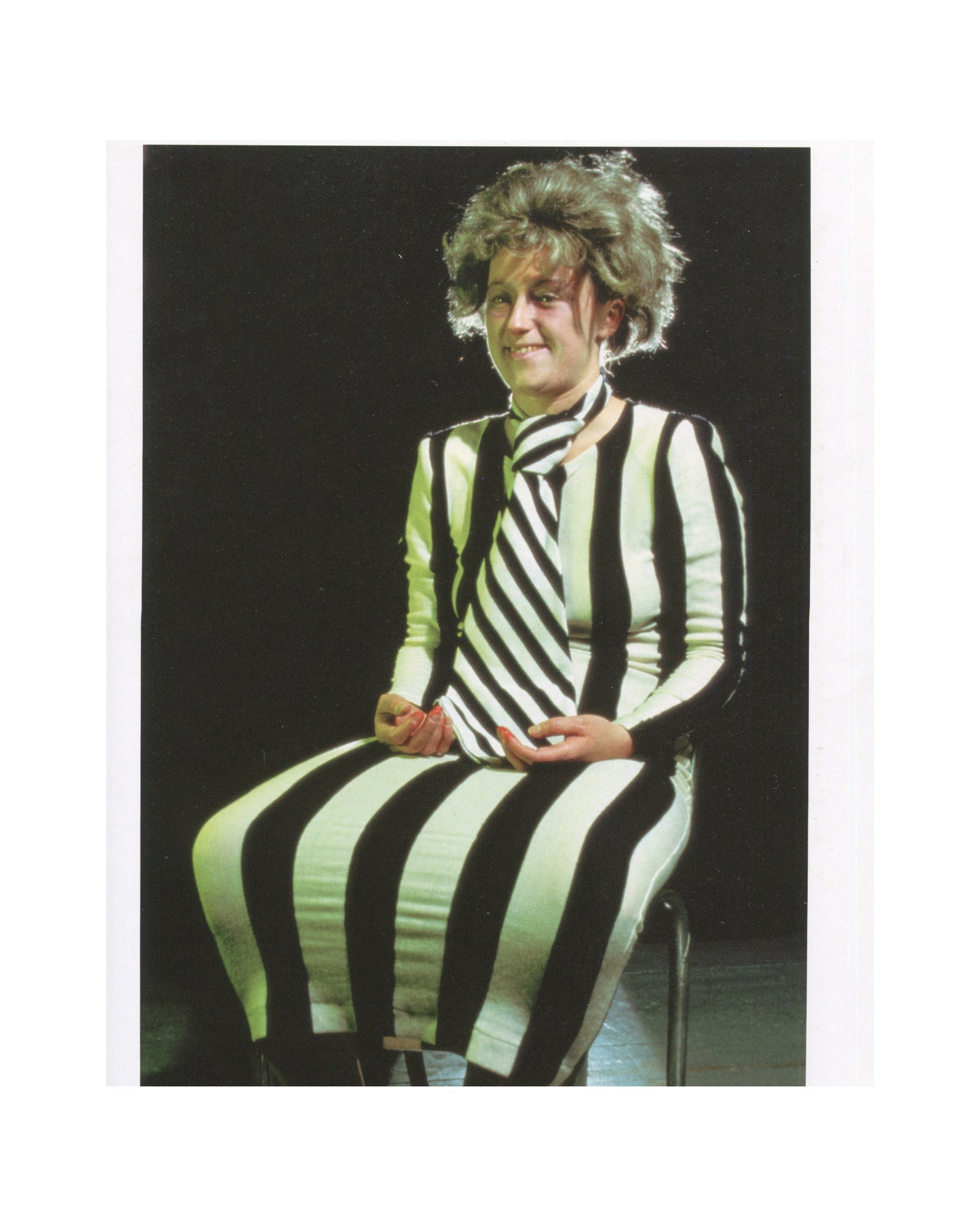 Cindy Sherman, Photographic Work 1975–1995, Schirmer/Mosel 1995, interior page: Sherman seated in black-and-white striped dress, wild grey wig, smiling, dark ground; faded from ex-library use