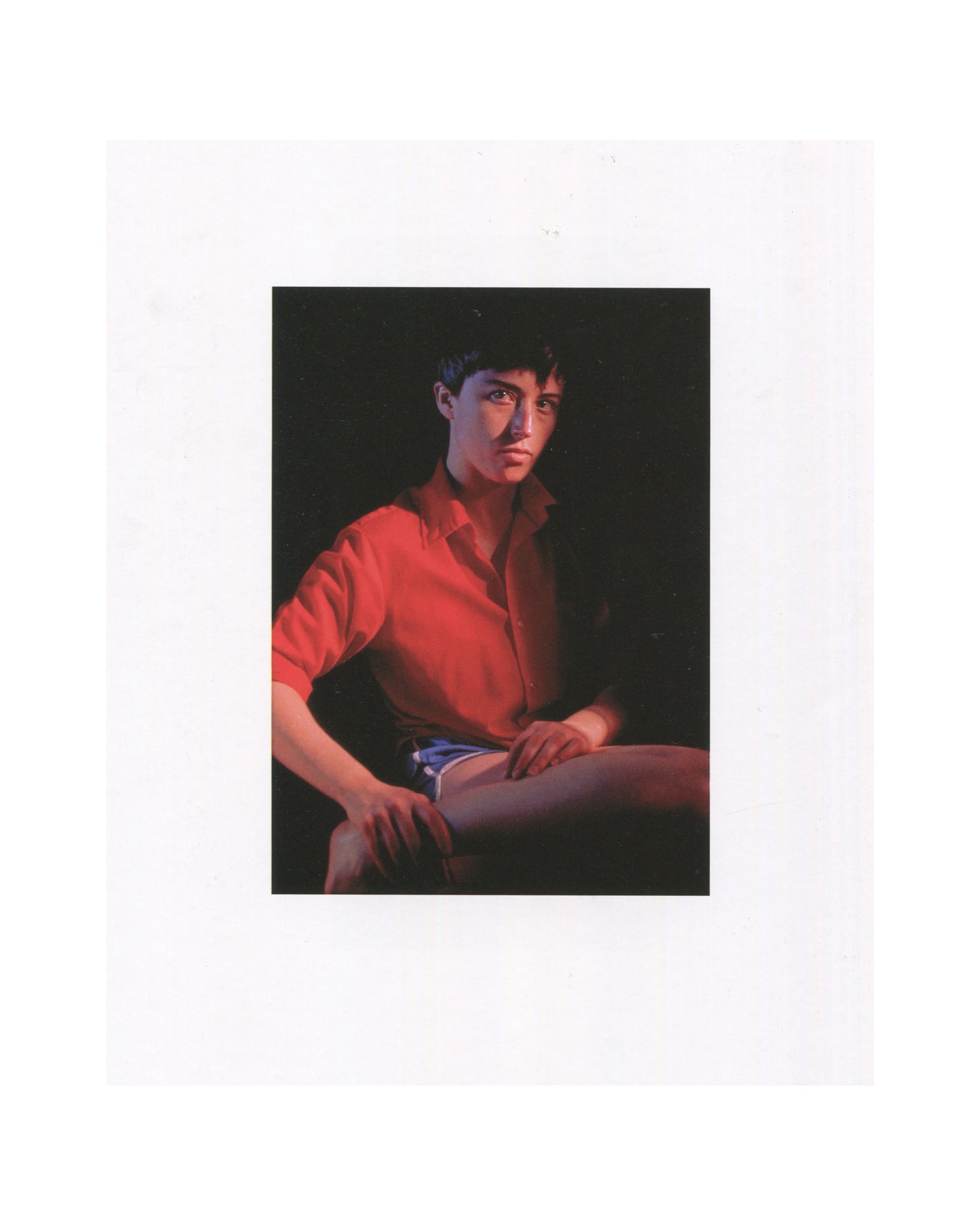 Cindy Sherman, Photographic Work 1975–1995, 1995, interior: colour Untitled #224, 1990 — Sherman as androgynous youth in red shirt, dark hair, seated, dark ground; caption below
