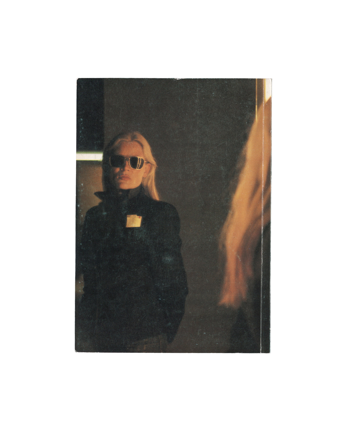 Katharina Sieverding, Grossfotos I–X, 1977, rear cover: colour photograph of blonde figure in black jacket and large sunglasses with gold brooch, dark studio