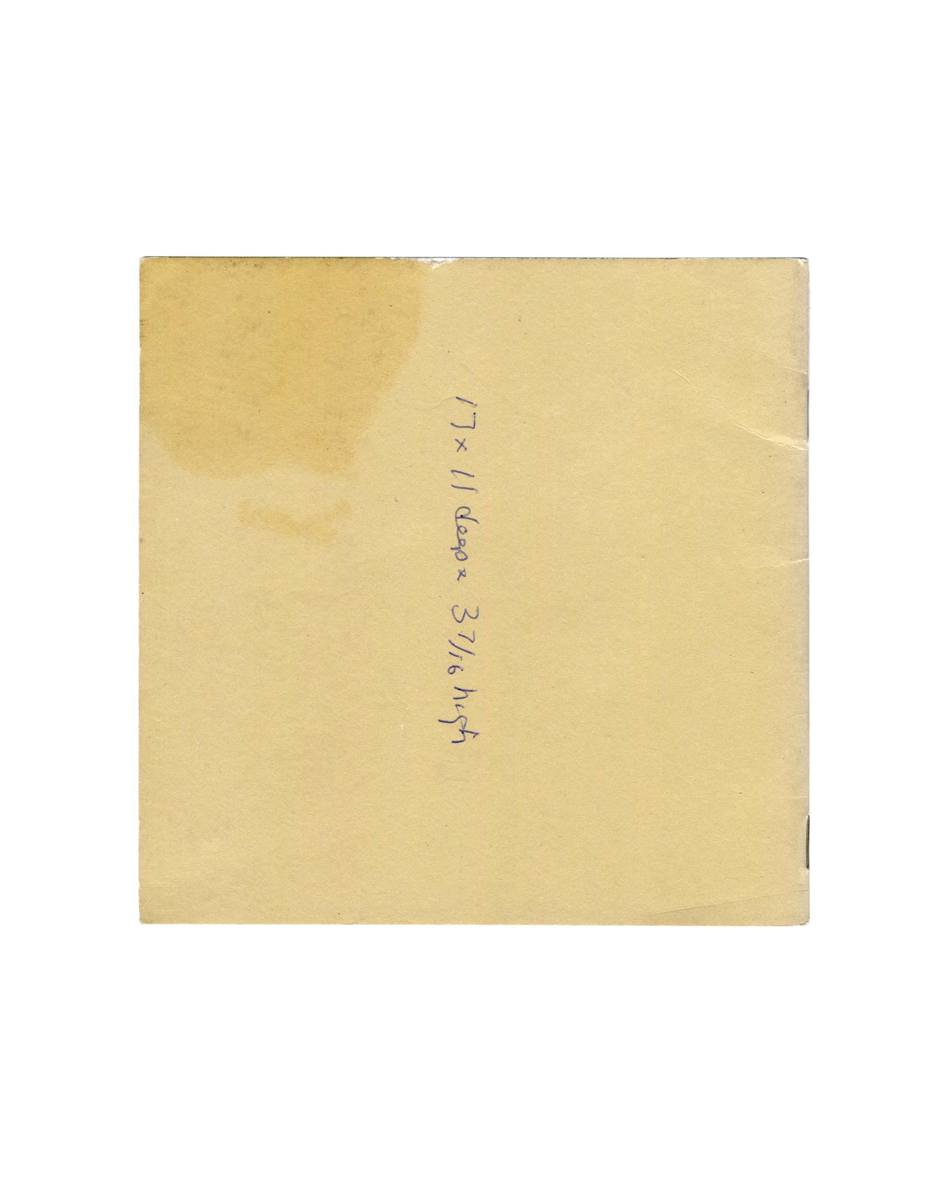 Back cover, William Wegman, New Paintings, Polaroids and Drawings / Early Black and White Photographs, Holly Solomon Gallery & Pace/MacGill Gallery, New York, 1991. Plain tan paper ground. Handwritten note in blue ballpoint pen, rotated 90°, reading '17 × 11 deep × 3 7/16 high'. Light toning, rubbing, and edge wear consistent with good vintage condition.


