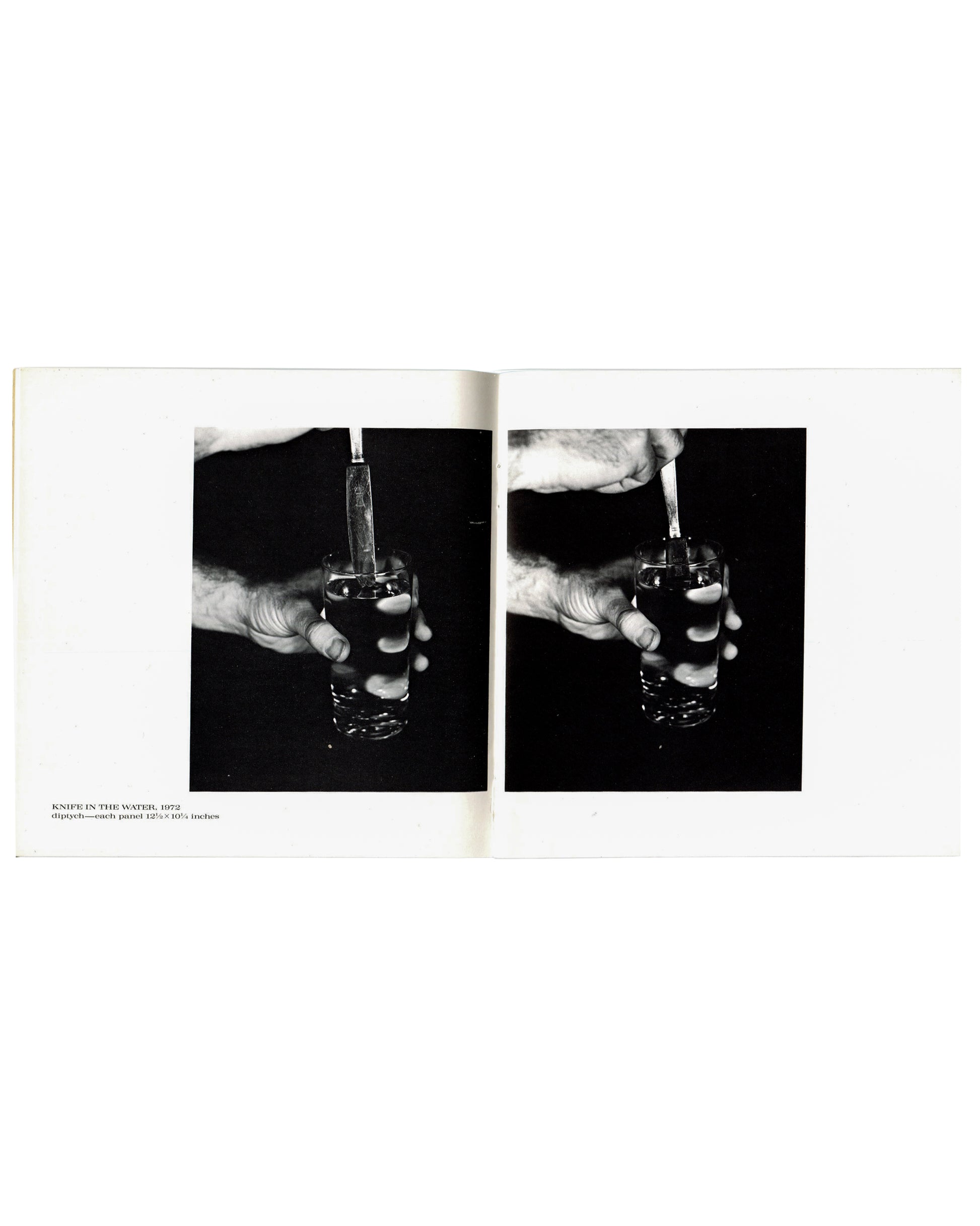 Interior spread, William Wegman, New Paintings, Polaroids and Drawings, Holly Solomon Gallery & Pace/MacGill Gallery, New York, 1991. Caption lower left: 'KNIFE IN THE WATER, 1972 / diptych — each panel 13⅝ × 10½ Inches'. Two black-and-white photographs side by side — close-up of hand gripping a glass of water with a knife inserted; dark studio background; slight variation between panels.