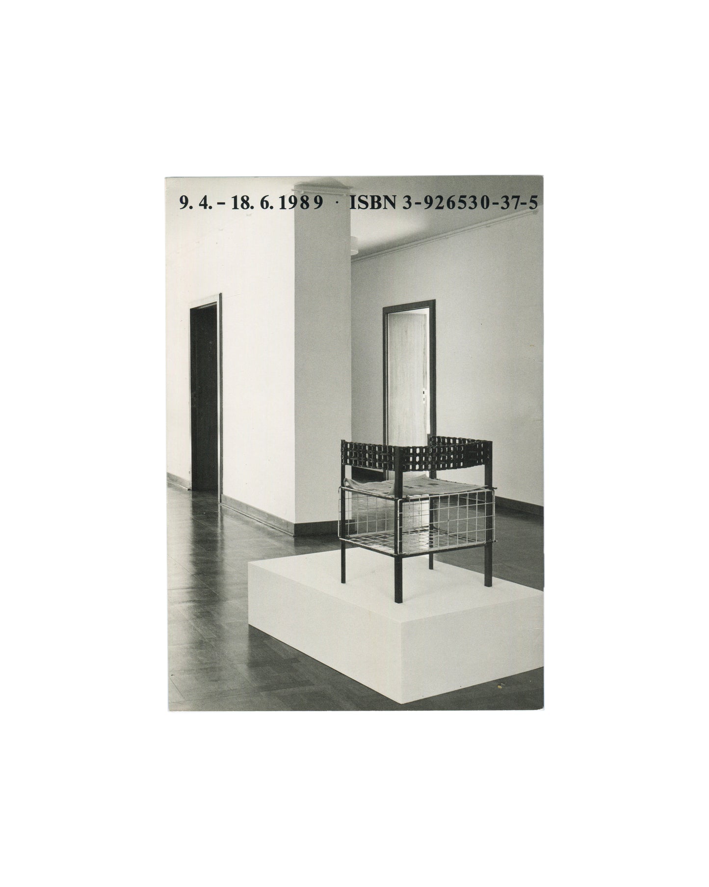 Back cover, Franz West, Museum Haus Lange, Heft 1, Krefelder Kunstmuseen, Krefeld, 1989. Black-and-white installation photograph by Günther Förg — single wire-frame and perforated-metal chair sculpture on white plinth; white gallery walls, dark floor, doorway and mirror visible. Black serif text above: '9. 4. – 18. 6. 1989 · ISBN 3-926530-37-5'. Light handling marks.



