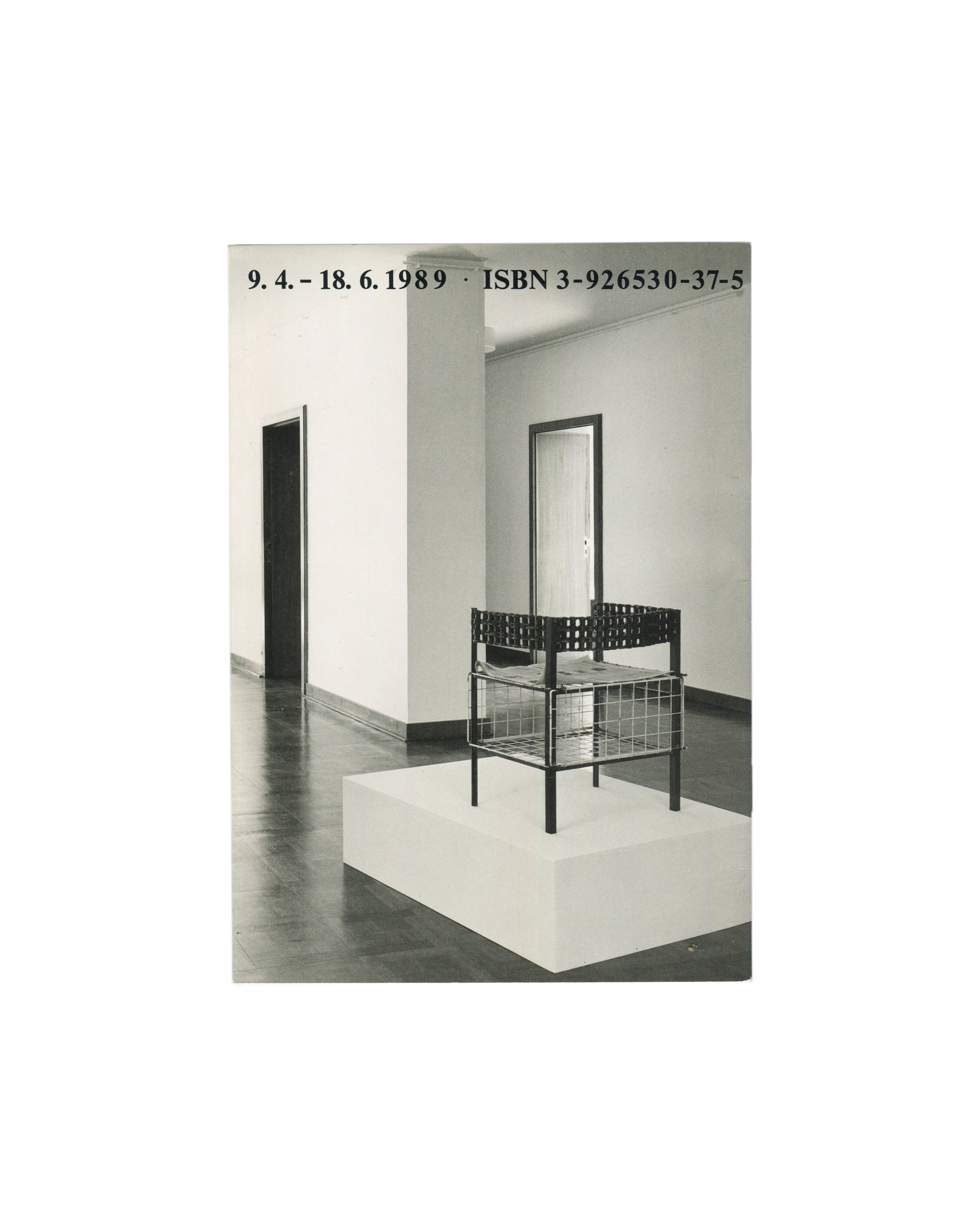 Back cover, Franz West, Museum Haus Lange, Heft 1, Krefelder Kunstmuseen, Krefeld, 1989. Black-and-white installation photograph by Günther Förg — single wire-frame and perforated-metal chair sculpture on white plinth; white gallery walls, dark floor, doorway and mirror visible. Black serif text above: '9. 4. – 18. 6. 1989 · ISBN 3-926530-37-5'. Light handling marks.



