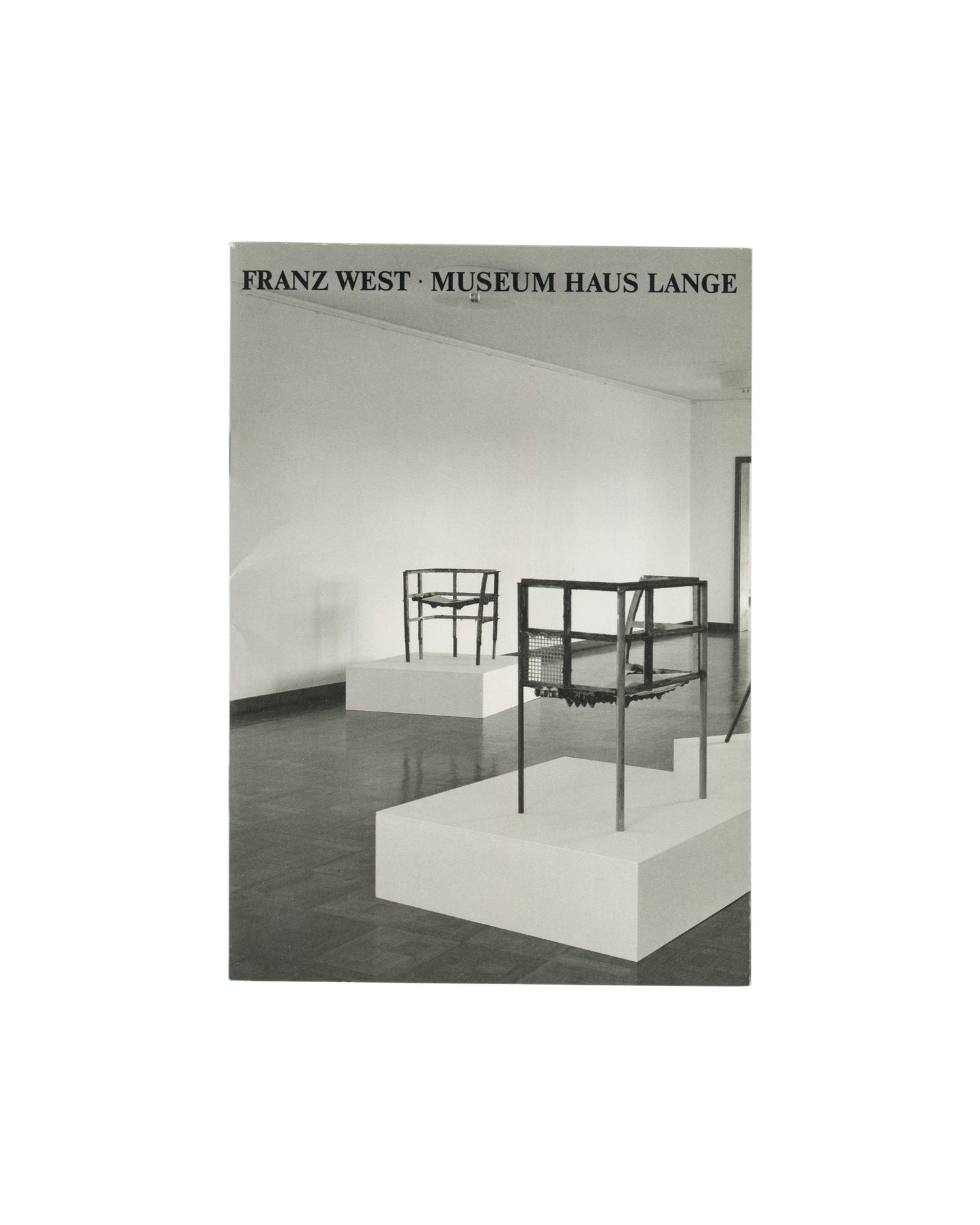 Stapled softcover booklet, Franz West, Museum Haus Lange, Krefelder Kunstmuseen, Krefeld, 1989. Cover: black-and-white installation photograph by Günther Förg — two wire-frame chair sculptures on white plinths, dark reflective floor, white gallery walls. Black serif text above: 'FRANZ WEST · MUSEUM HAUS LANGE'. Good vintage condition, light handling marks.