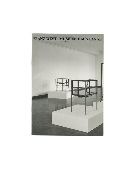 Stapled softcover booklet, Franz West, Museum Haus Lange, Krefelder Kunstmuseen, Krefeld, 1989. Cover: black-and-white installation photograph by Günther Förg — two wire-frame chair sculptures on white plinths, dark reflective floor, white gallery walls. Black serif text above: 'FRANZ WEST · MUSEUM HAUS LANGE'. Good vintage condition, light handling marks.