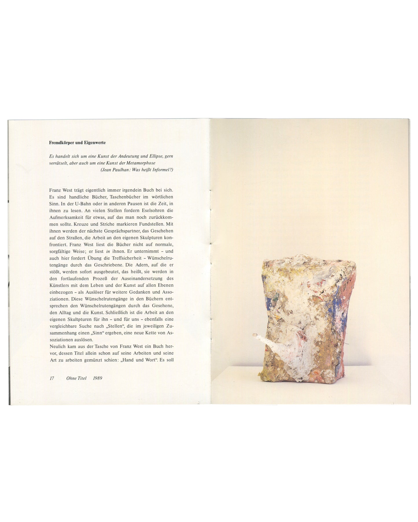 Interior spread, Franz West, Museum Haus Lange, Heft 1, Krefelder Kunstmuseen, Krefeld, 1989. Left page: essay 'Fremdkörper und Eigenwerte' by Julian Heynen in small serif type, two columns; italic epigraph from Jean Paulhan: 'Was heißt Informel?'; caption lower left '17  Ohne Titel  1989'. Right page: colour photograph of Franz West, Ohne Titel, 1989 — compact cubic papier-mâché sculpture, surface painted in pale pink, blue, grey, and cream with visible brushwork; set against warm cream ground. Photograph 