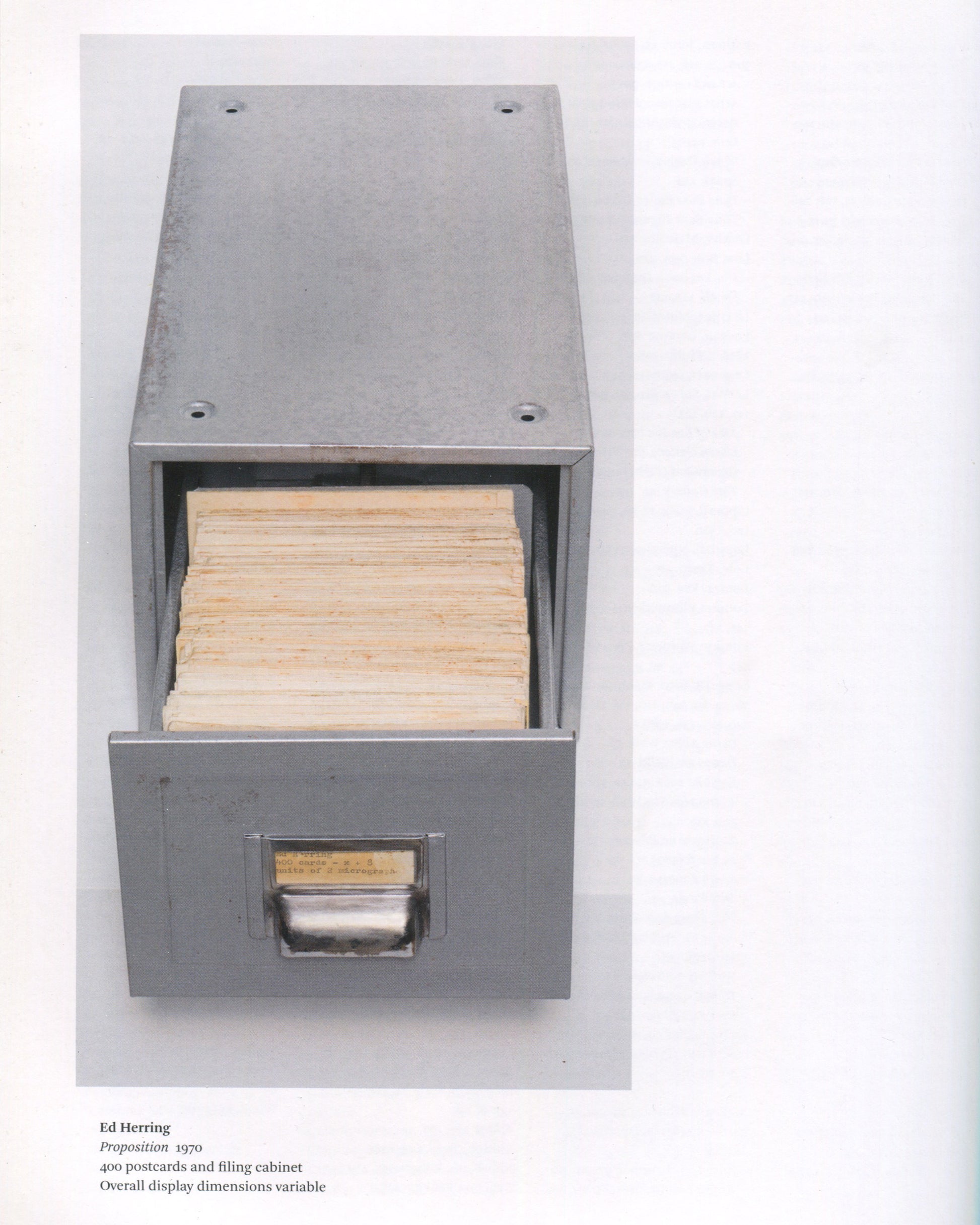 Ed Herring, Proposition, 1970, in Conceptual Art in Britain 1964–1979, Tate 2016 — open metal filing cabinet drawer packed with 400 aged postcards; caption below